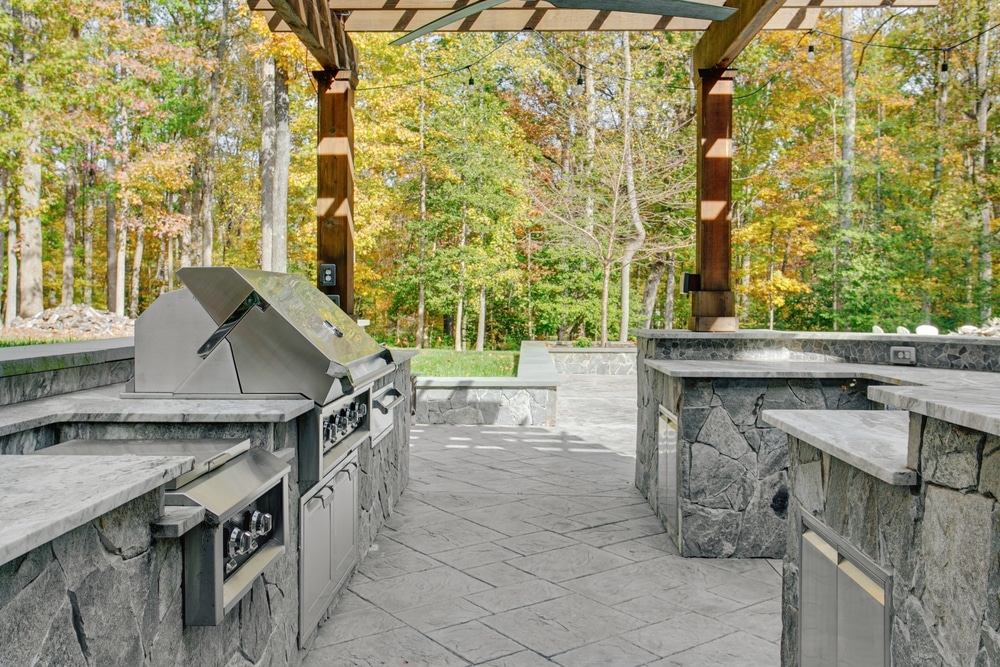 inviting,partially,covered,outdoor,patio,with,large,stone,kitchen,island,